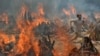 INDIA -- A man runs to escape the heat from multiple funeral pyres of COVID-19 victims at a crematorium on the outskirts of New Delhi, India, on April 29, 2021. (AP Photo/Amit Sharma)