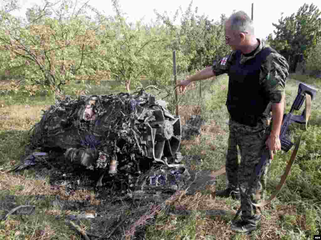 Грузінскі вайсковец каля зьбітага расейскага самалёта непадалёк ад вёскі Дзэвэра за 100 кілямэтраў ад Тбілісі, 9 жніўня